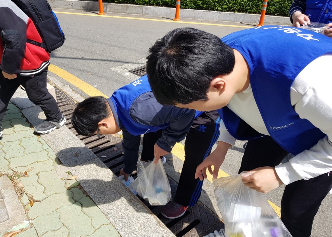 주간보호센터 이용자들이 파란 조끼를 입고 복지관 인근 거리의 쓰레기를 줍고 있는 모습