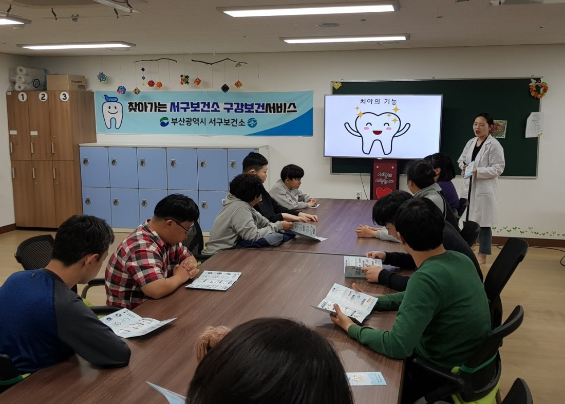 주간보호센터 이용자들이 서구보건소 직원에게 치아의 기능에 대해 설명을 듣고 있는 모습
