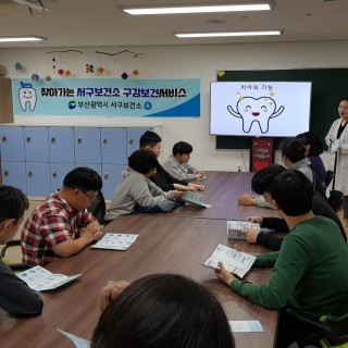 주간보호센터 이용자들이 서구보건소 직원에게 치아의 기능에 대해 설명을 듣고 있는 모습