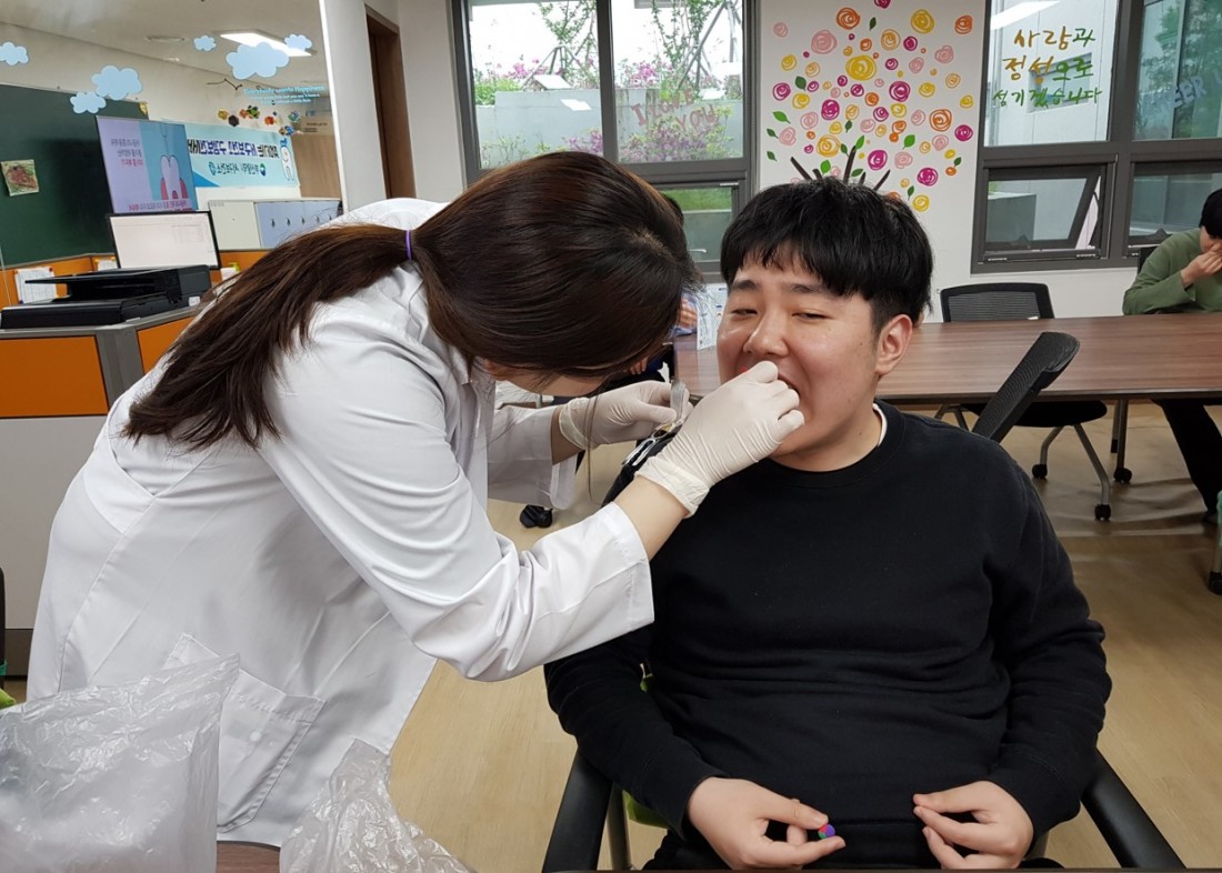 주간보호센터 이용자들이 서구보건소 직원에게 구강 점검을 받고 있는 모습