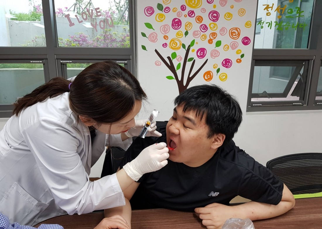 주간보호센터 이용자들이 서구보건소 직원에게 구강 점검을 받고 있는 모습