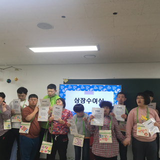 주간보호센터 이용자들이 어린이 날을 맞이하여 상장을 들고 서 있는 모습