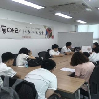 독서동아리에 참여한 학생들이 강사가 읽어주는 책을 바라보고 있는 모습