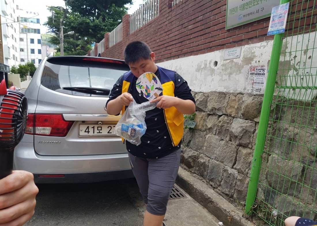 주간보호센터 이용자가 인근학교의 쓰레기를 줍는 모습