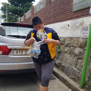 주간보호센터 이용자가 인근학교의 쓰레기를 줍는 모습