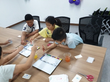 여름방학에 참여한 아이들이 밝게 웃으며 미술활동에 참여하는 모습