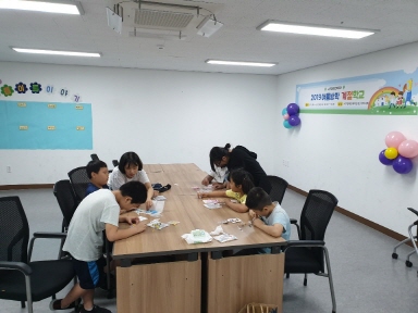 실습생들과 아동들이 함께 종이를 활용한 미술활동을 진행하고 있는 모습