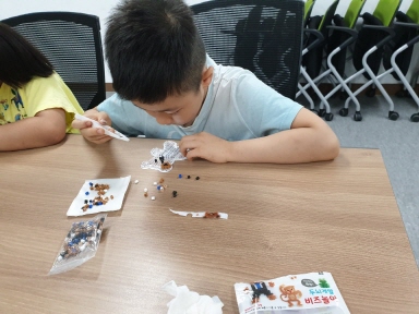 여름방학에 참여한 아이들이 밝게 웃으며 미술활동에 참여하는 모습