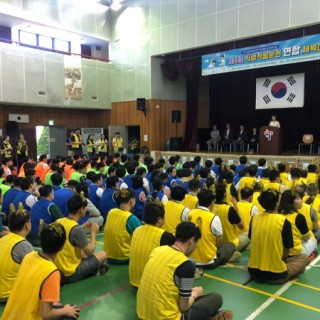 연합체육대회에서 팀별로 줄을 맞춰 앉아있는 사람들의 모습