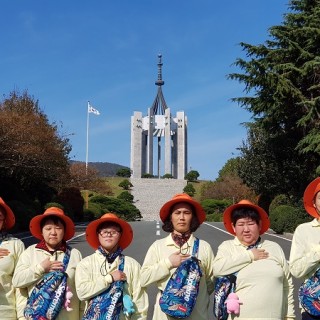 중앙공원 충혼탑을 배경으로 찍은 기념사진 이용자들이 왼쪽가슴에 손을 올리고 있다