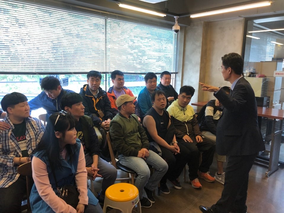 직업적응훈련반 훈련생들이 부산커피협동조합에 방문하여 설명을 듣는 모습
