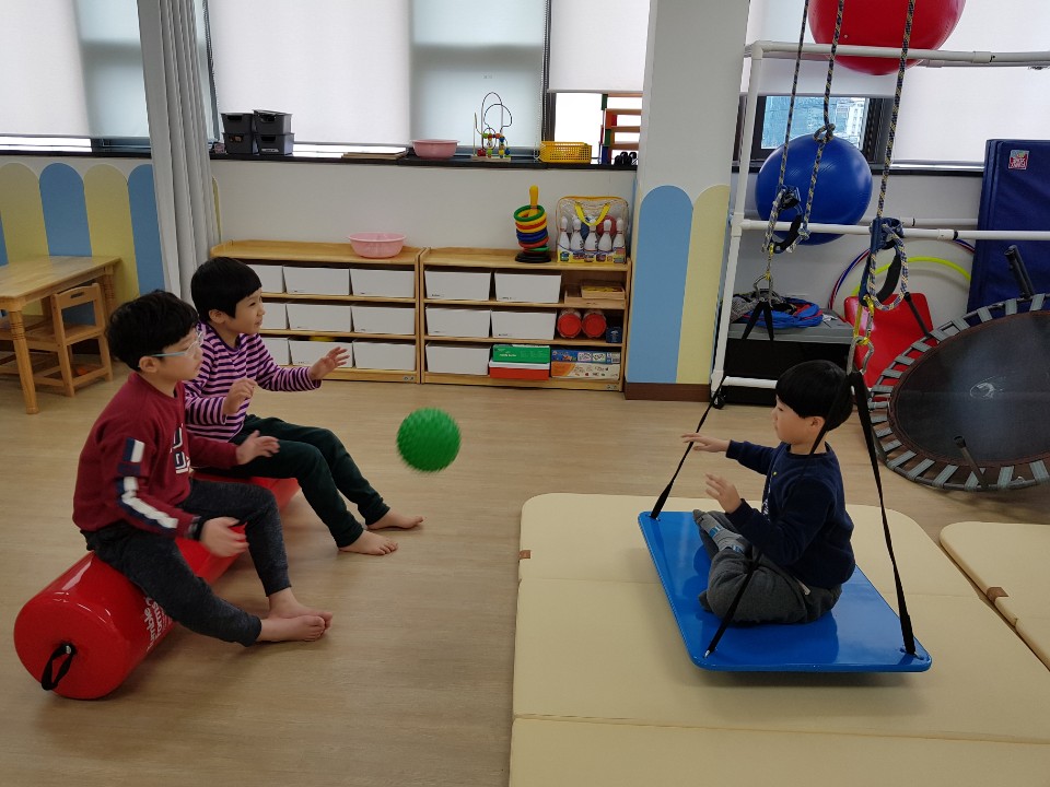 감각통합그룹치료에 참여한 아동들이 서로 마주보고 공을 주고 받는 모습