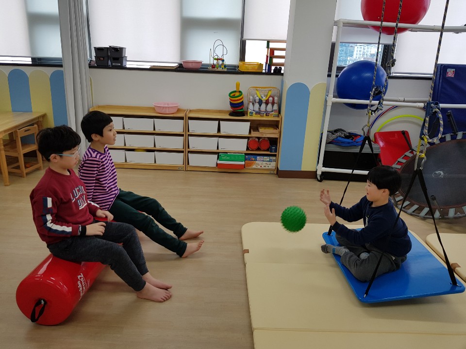 감각통합그룹치료에 참여한 아동들이 서로 마주보고 공을 주고 받는 모습