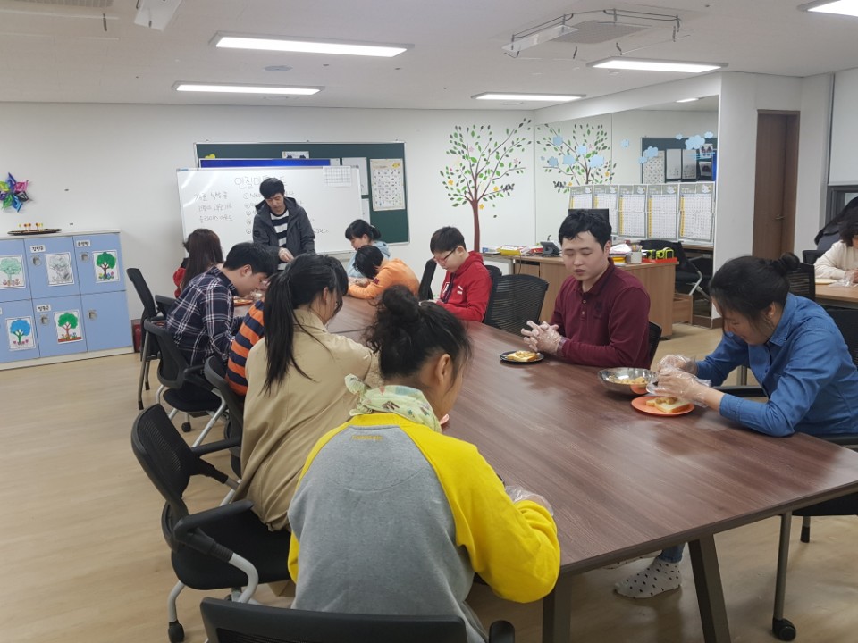 이용자들이 손에 비닐장갑을 끼고 선생님의 설명에 따라 만들기를 진행하는 모습