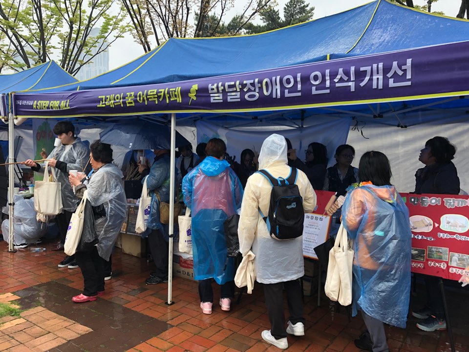발달장애인 인식개선 부스에 사람들이 관심을 가지고 다가가는 모습
