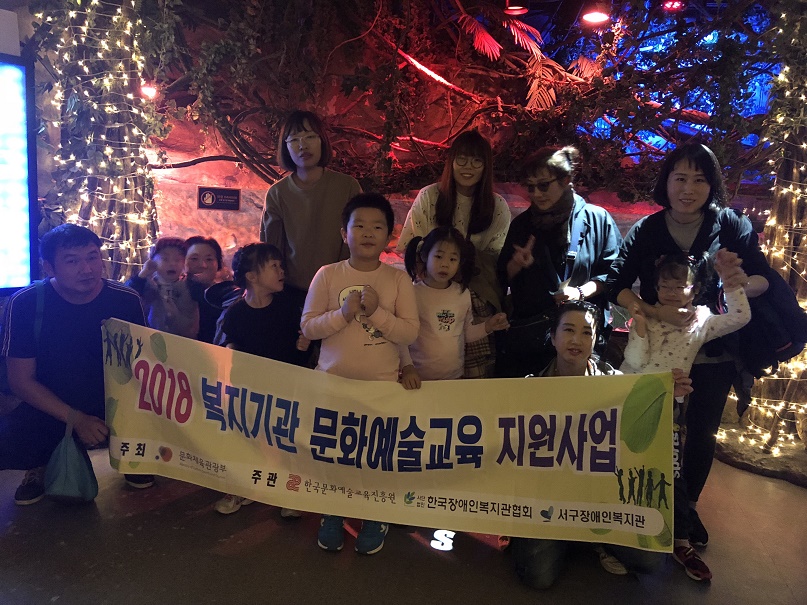무용교실의 참여아동들과 부모님들이 함께 현수막을 들고 찍은 기념사진