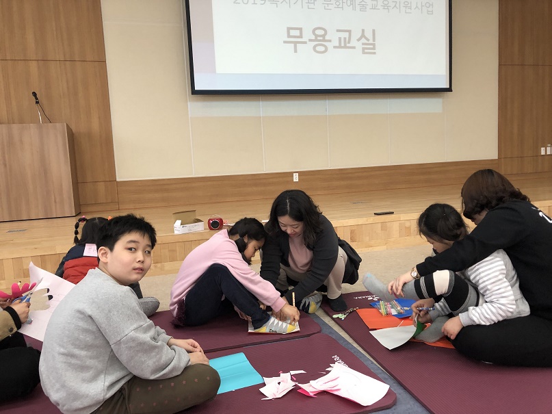 참여아동들이 강사와 함께 자신의 손, 발의 크기에 맞춰 그림을 그리는 모습