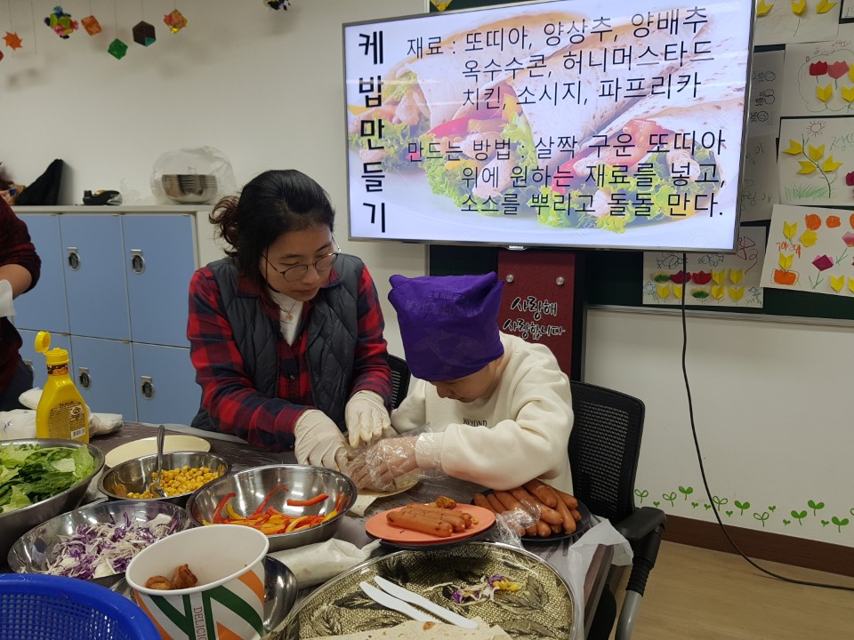 담당 교사와 함께 이용자가 케밥 속재료를 만드는 모습