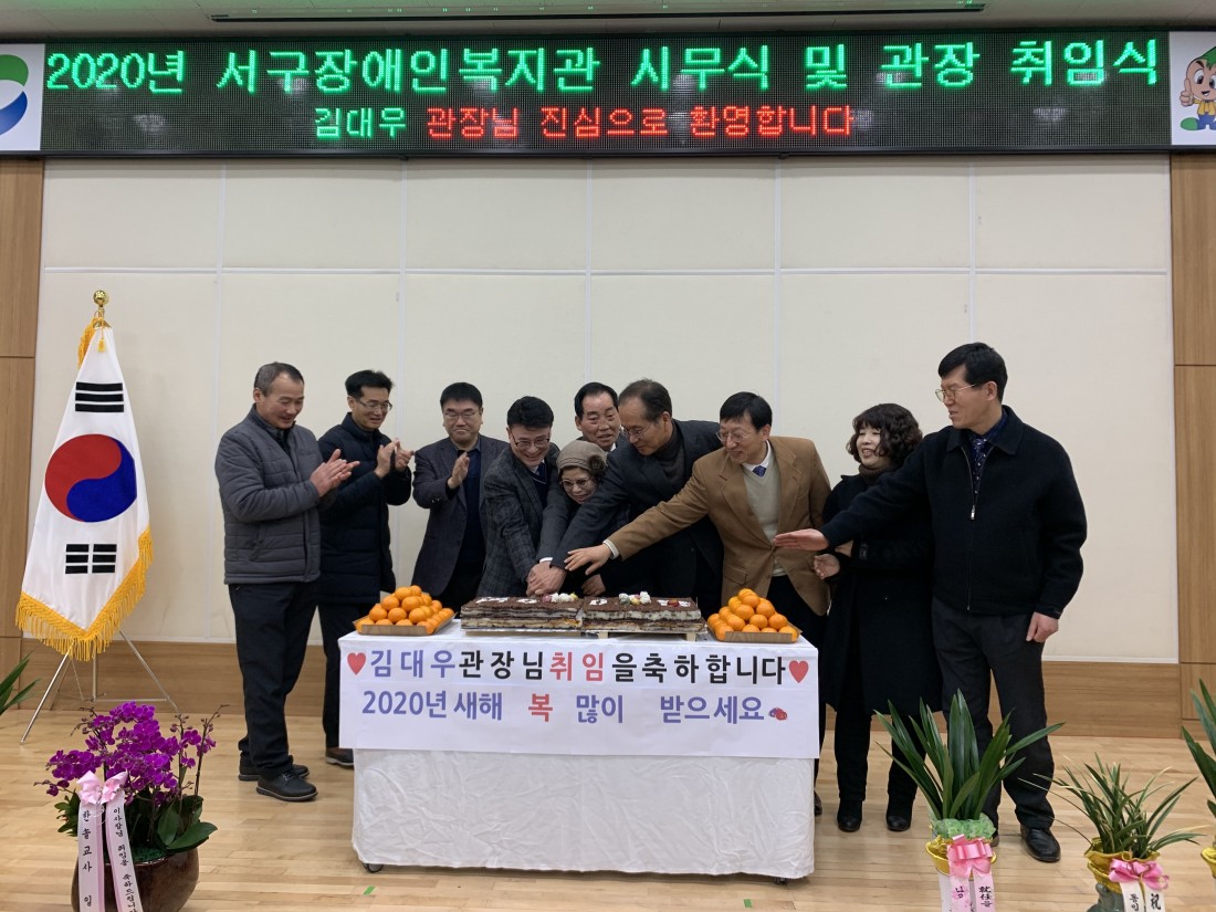 운영위원 및 내빈들과 김대우 관장님이 취임기념 떡 커팅식을 진행하는 모습