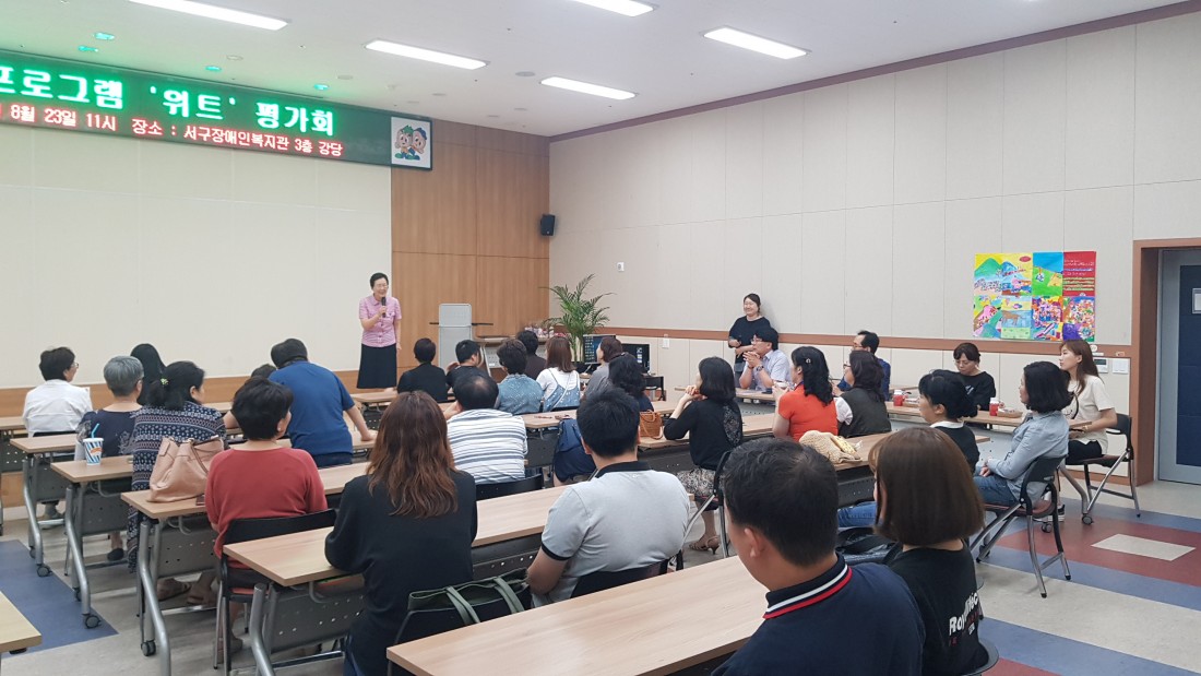 장애청년프로그램 위트의 마무리를 하기 위해 인삿말을 전하고 있는 관장님과 집중해서 듣고 있는 참여자들의 모습