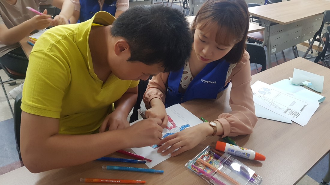 청소년진로체험 청진기 프로그램에서 그림을 그리고 있는 참가자와 도와주는 복지사의 모습
