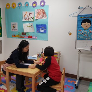 미술치료사가 치료아동이 그림 그림을 보고 있는 모습