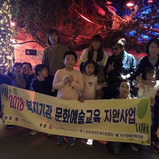무용교실의 참여아동들과 부모님들이 함께 현수막을 들고 찍은 기념사진
