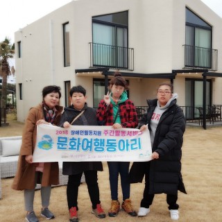 주간활동서비스 이용자들이 담당직원과 함께 현수막을 들고 숙소앞에서 찍은 사진