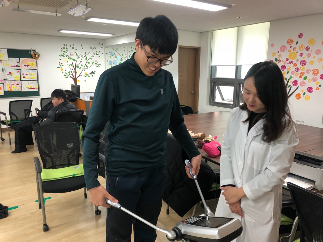 직업적응훈련반 훈련생이 보건소 직원의 설명에 따라 인바디 체크를 진행하는 모습