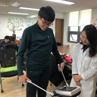 직업적응훈련반 훈련생이 보건소 직원의 설명에 따라 인바디 체크를 진행하는 모습