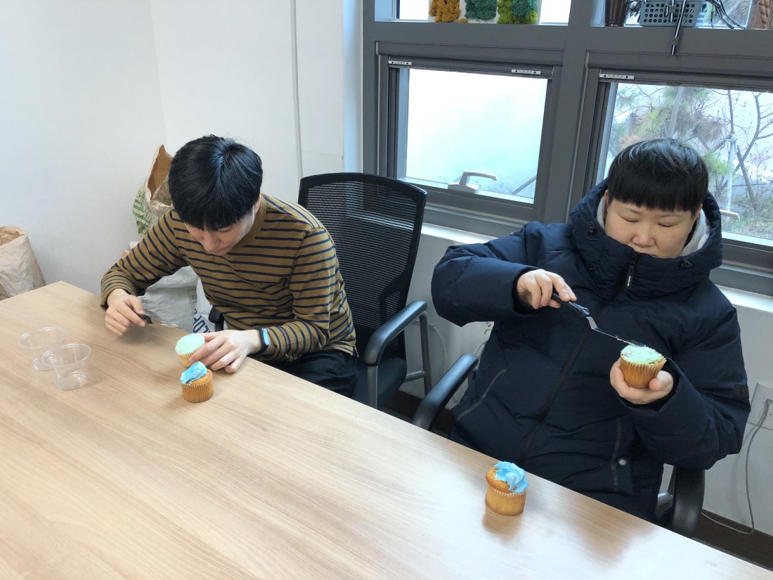 훈련생들이 각각 자신이 원하는 색상의 크림을 빵에 넓게 펴바르고 있는 모습